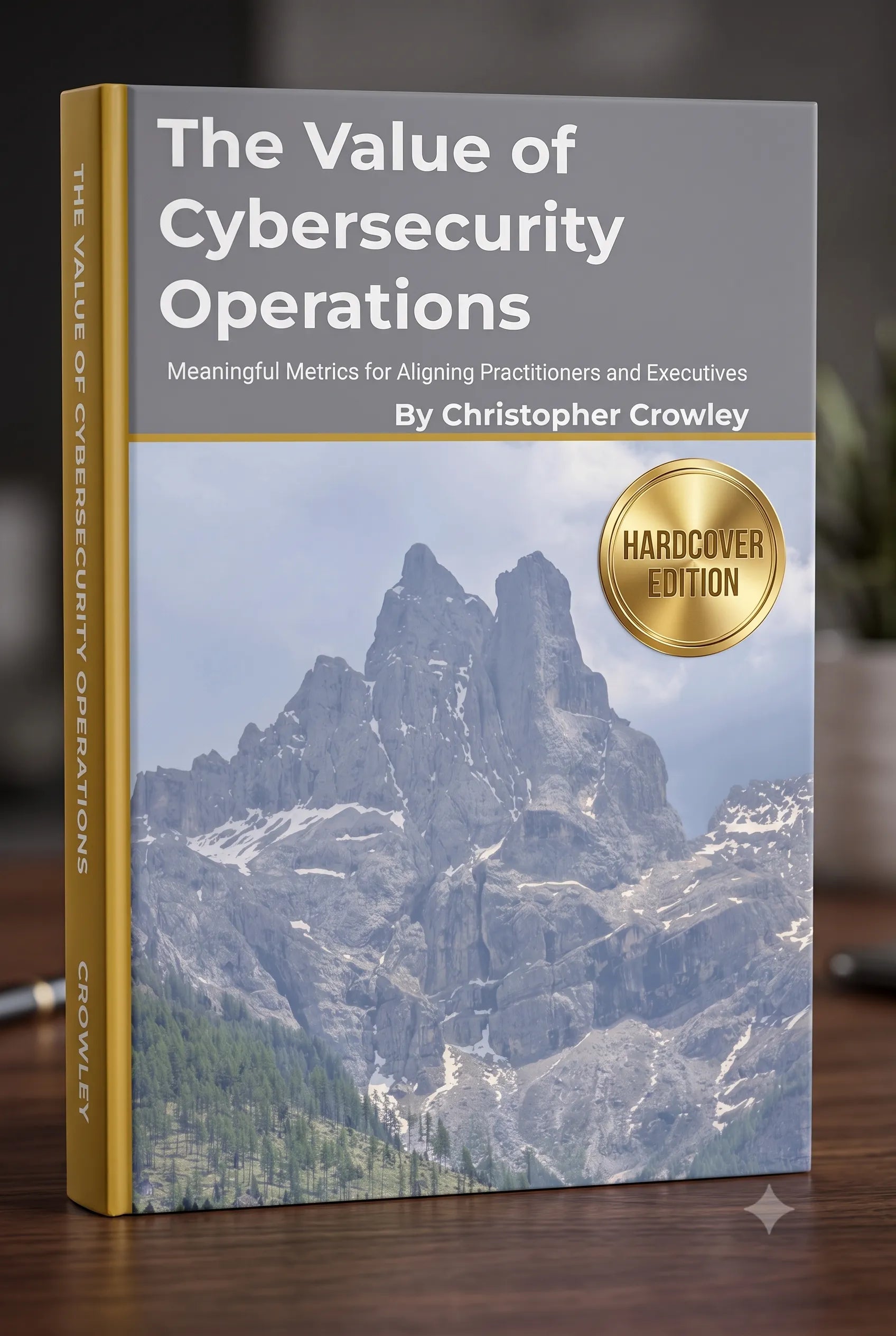 The Value of Cybersecurity Operations Hardcover Edition book by Christopher Crowley, featuring a gray cover with white text and a mountain landscape photo, set on a wooden surface.